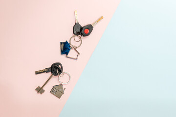 Keys with keychain with shape of house on two colored background