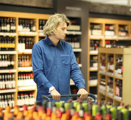 man choosing a wine, champagne at supermarket.