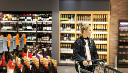 Woman choosing a dairy products at supermarket.woman choosing a wine, champagne at supermarket