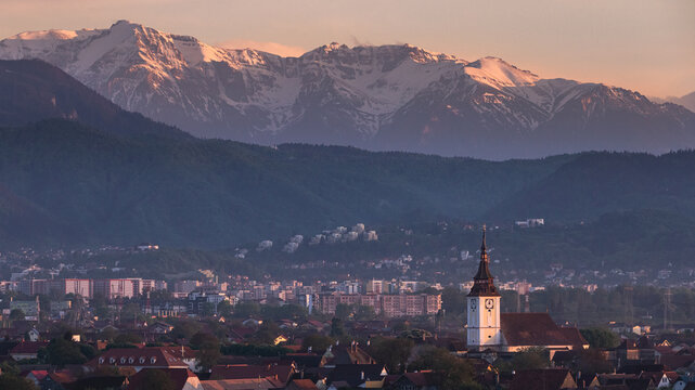 Sanpetru village in Transylvania, Romania in magenta tones at sunset with the Bucegi mountains in the background
