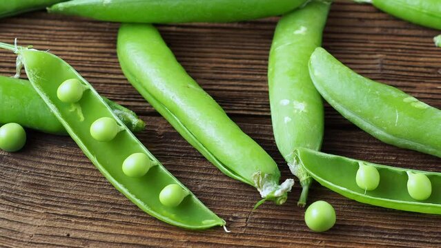 Fresh pea pods on a wooden background