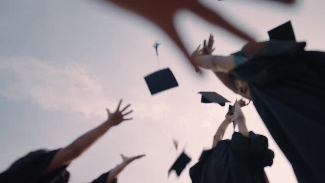 Close-up of graduation ceremony university high school graduates throwing cap on the blue sky.