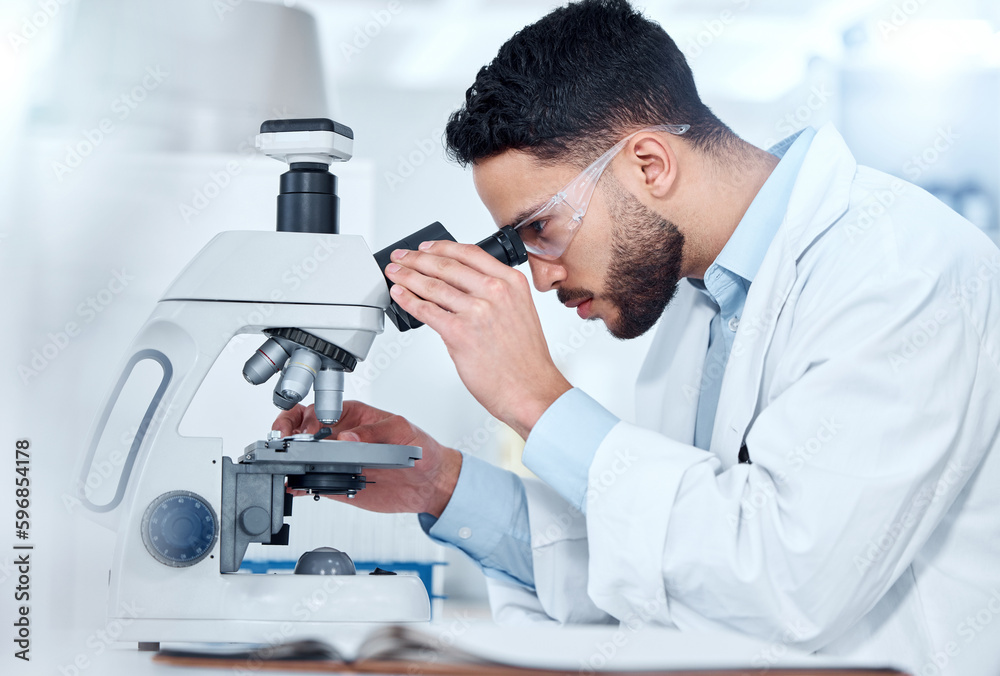 Aufkleber One serious medical scientist sitting at a desk and using a microscope to examine and analyse test samples on slides. Hispanic healthcare professional discovering a cure for diseases in his laboratory