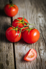 Bunch of fresh, red tomatoes on a wooden rustic board. Healthy and fresh ripe