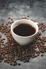 close up view of brown coffee seeds with cup of coffee dark surface textured cocoa grain