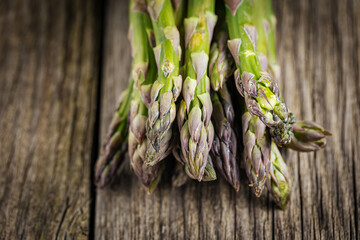 Bunch of green asparagus on rustic wooden board. Fresh and seasonal ingredient.