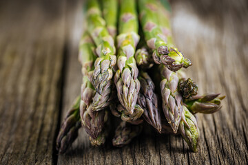 Bunch of green asparagus on rustic wooden board. Fresh and seasonal ingredient.