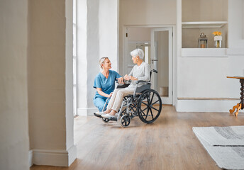 I hope you stay in good spirits. Shot of a nurse caring for a senior woman in a wheelchair in a...
