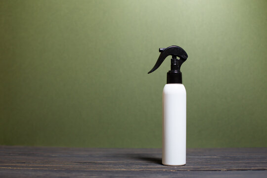 A white bottle with a black sprayer on a beautiful background, spray