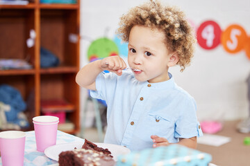 Preschool sure is sweet. Shot of a little boy eating cake in class.