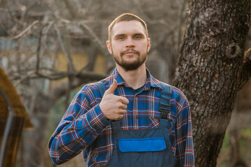 Farmer satisfied european appearance rural portrait with beard, shirt and overalls looking at...