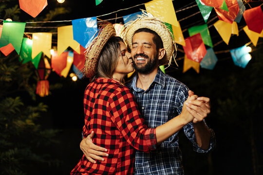 Brazilian couple wearing traditional clothes for Festa Junina - June  festival - dancing under the night sky Stock Photo | Adobe Stock