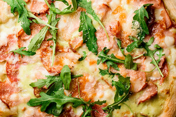 Ready-made mini pizza with jamon,ruccola covered with cheese. Top view