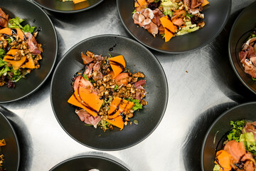 Tasty and healthy salad with jamon, salad mix, cheese, nuts and terijaki sause . Top view