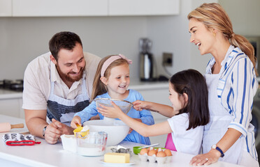 Obraz na płótnie Canvas Happy young family with kids in kitchen preparing dough for pastry while spending weekend together at home. Loving caucasian family preparing home bakery