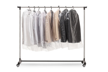 Clothing rack at dry cleaners with suits in plastic covers