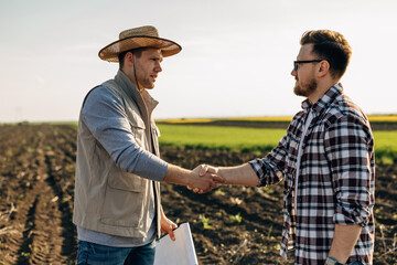 The farmer shakes hands with the man who leased the land to him © cherryandbees