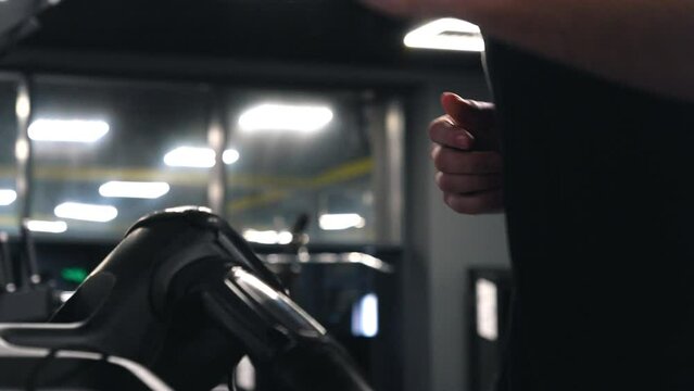 Panel focus, Exercise display, Distance tracker. Control panel treadmill being operated by man's hands pressing buttons.