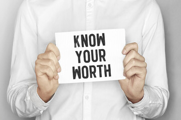 Man holding a paper card with text Know Your Worth