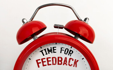 Red alarm clock with text Time for feedback