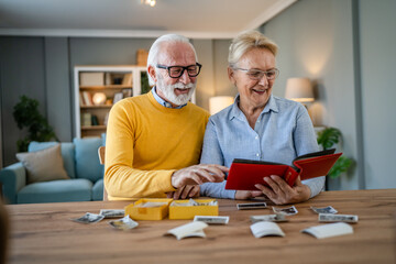Senior couple man and woman husband wife looking family photos album