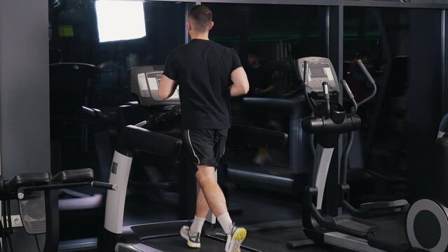 Male Athletic, Youthful Male, Running Treadmill. Youthful male engages in athletic activities at gym, running on treadmill.