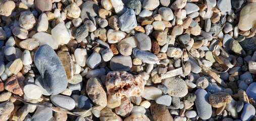 Sea stone pebbles background. Abstract nature background with pebble stones. Full frame of colorful pebbles. Close-up. stones of different colors, shapes and sizes