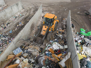 Heavy construction machine, front end loader moving along recycling center area, close up view....