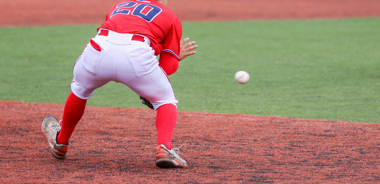 Third baseman fielding the ball during a baseball game - Powered by Adobe
