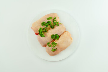 Chicken leg meat.Raw fresh chicken leg meat with skin and with fresh herbs on a white background.Copy space.Copy space.Food for retail.Procurement for designers.Ogranic food,healthy eating.Food