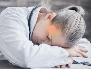 I need to care for myself first before I see to others. Shot of a mature doctor sleeping at her desk while experiencing a headache in a medical office.