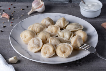Traditional russian pelmeni, ravioli, dumplings with meat on a wooden table