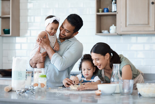 Mom is the best baker. Shot of a woman baking in the kitchen with her husband and two daughters.
