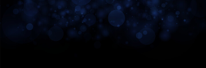 Abstract defocused circular blue bokeh on dark background. 