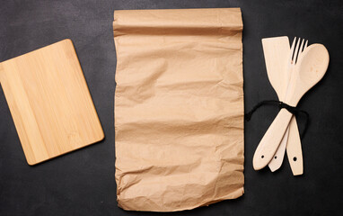 Wooden spoon, fork and brown sheet of paper