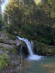 Mountain waterfall against the backdrop of a forest in the Ukrainian Carpathians