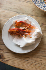 Shrimps head waste on a fancy plate on a seafood restaurant table.