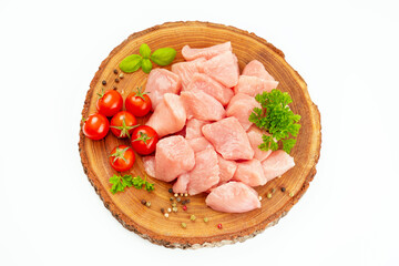 Fresh pieces of turkey meat.Raw chicken.Raw pieces of turkey meat with greens and tomatoes on a wooden board against a white background.Ogranic food and healthy eating.chicken fillet.