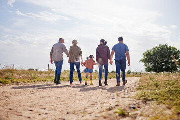 Fototapeta na wymiar Living a simple, rural life. Shot of a multi-generational family walking together on a farm.