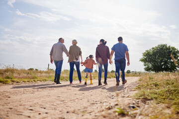 Living a simple, rural life. Shot of a multi-generational family walking together on a farm.