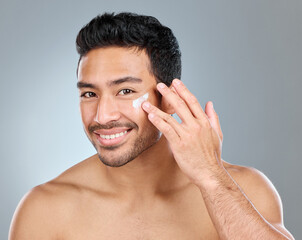This product is great for acne-prone skin. Shot of a man applying moisturiser to his face while...