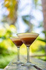 Two glasses of espresso martini at a beach bar in the Maldives