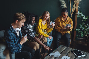 Diverse group of young people, friends, college students gathering together, have fun, playing games, laughing. Concept of diversity, international friendship, learning foreign languages, university