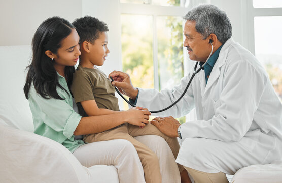 Always listen to your heart. shot of a mature doctor doing a checkup on a little boy at home.