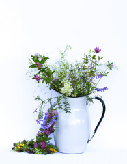 A bouquet of wildflowers in metal jug. Floral decor.