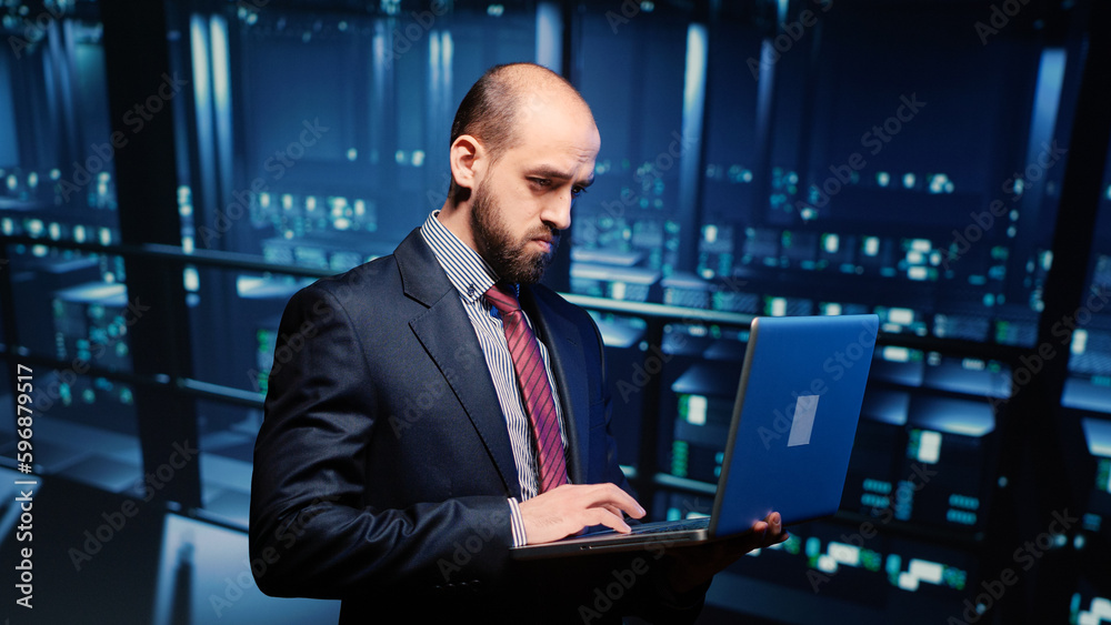 Poster server technician specialist activating hardware server system using laptop, standing in professiona