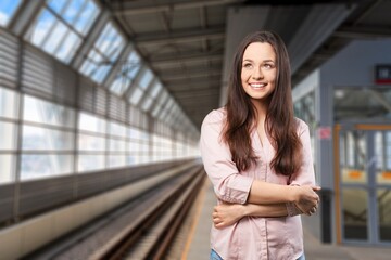 Happy young woman going on train station