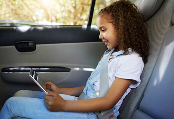 The road is long but the company is great. Cropped shot of an adorable little girl using her tablet...