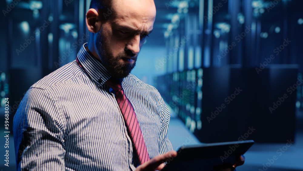 Poster data center it engineer standing next to server cabinets, activating hardware server system on digit