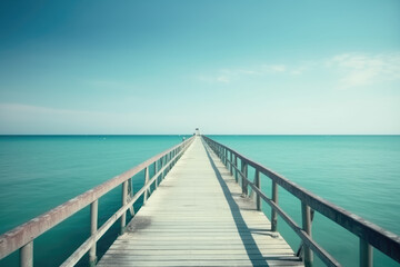 Fototapeta na wymiar Beautiful landscape with bridge to pier. Color fusion of ocean and sky. Light ripples on amazingly clear water. Perspective receding into distance. Image fine vacation on summer. Relax and rest